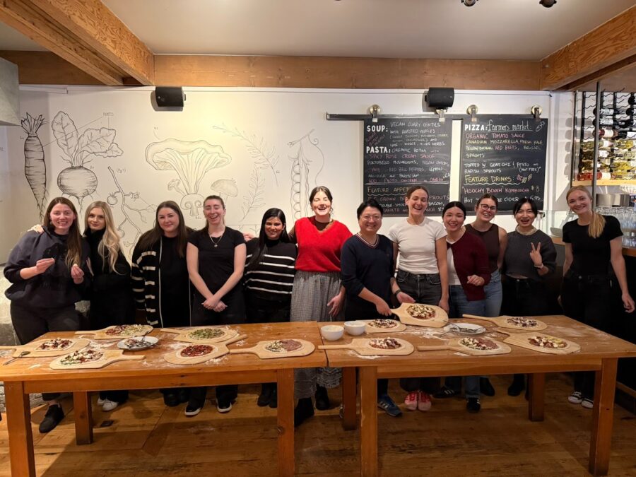our operations team standing in front of pizzas they made