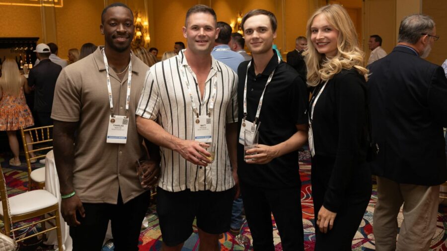 Three men and and one woman standing together at a conference