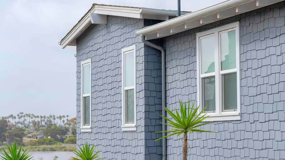 Coastal grey home using cedar for the siding with palm trees